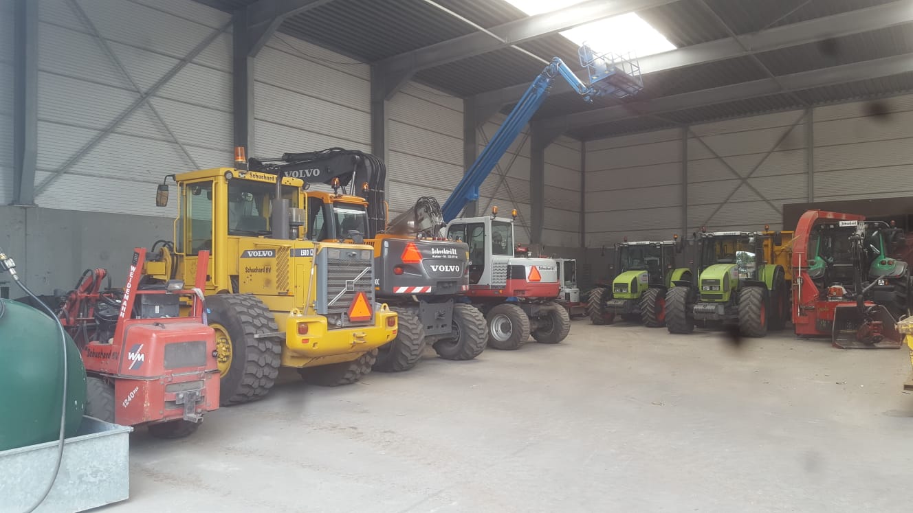 Het machinepark in de hal: shovels, kranen, Claas-trekkers en een hoogwerker
